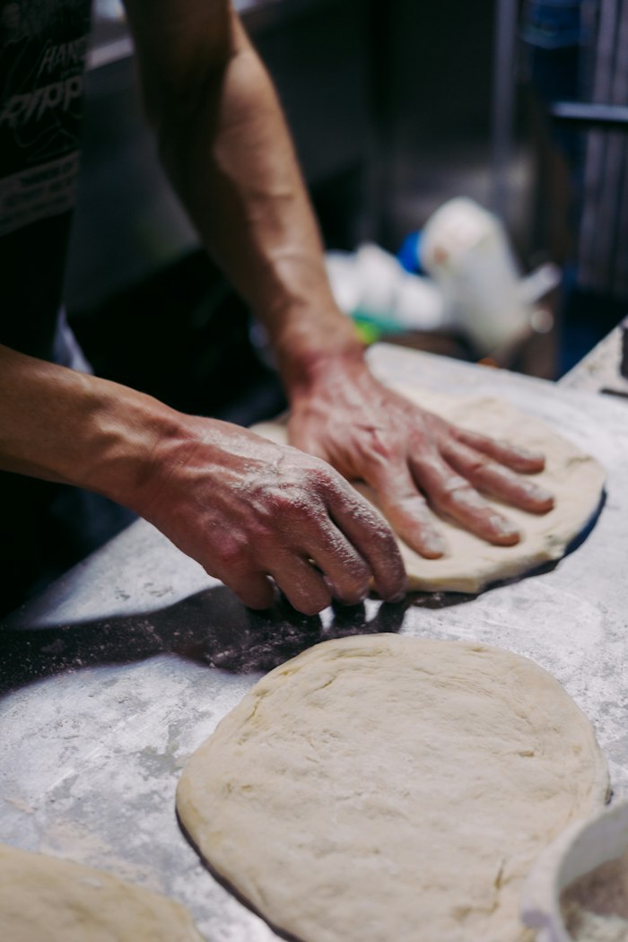 Pâte à pain travaillée à la main sur un plan de travail fariné