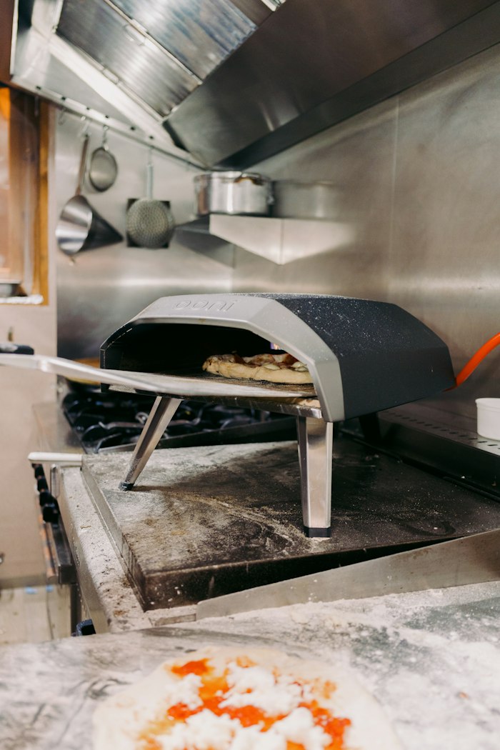 Pizza saisie dans un four à bois pendant l'atelier de cuisson